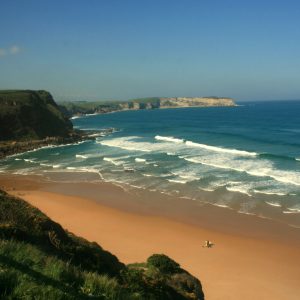 Surfistas paseando en la Playa de los Locos en Suances en Cantabria 