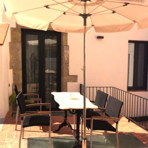 Terraza con sombrilla en el Hotel Sa Voga en Arenys de Mar en Cataluña