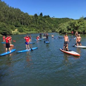 Chico cerca de un puente practicando stand up paddle en Guipuzcoa