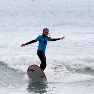 Alumna surfeando con Surf School Mallorca en la Playa Son Serra de Marina en Mallorca