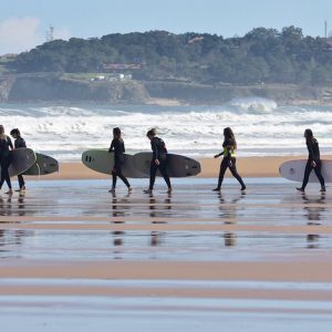 https://www.escuelacantabradesurf.com/es Chicas con las tablas de surf con la Escuela Cantabra de Surf en Somo en Cantabria