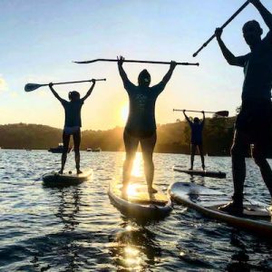 Grupo de turistas haciendo sup stand up paddle en San Vicente de la Barquera