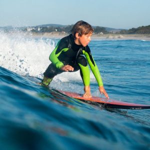 Niño haciendo un curso de surf inicial con la Escuela Cantabra de Surf en Somo en Cantabria