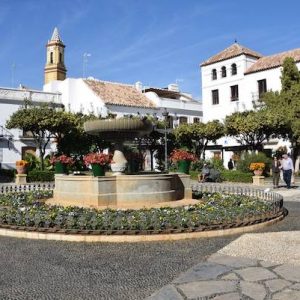 La Plaza de las Flores con gente paseando en Estepona en la provincia de Málaga