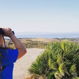 Chica observando aves en el centro internacional de Migración de Aves en Tarifa