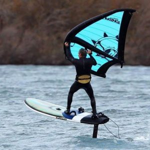 Deportista practicando wingfoil en una playa
