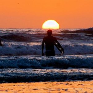 Alumno al atardecer de la escuela BM Surf en Laredo