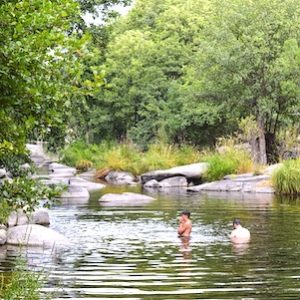 Turistas pegándose un baño en las piscinas naturales de Burgohondo