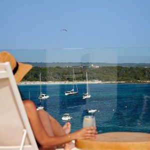 Turista tomando un refresco en la terraza del Hotel Honucai en Mallorca