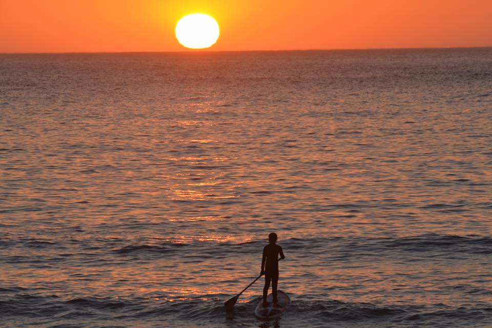 Alumno haciendo paddle surf con la Escuela de Surf los Locos en Suances