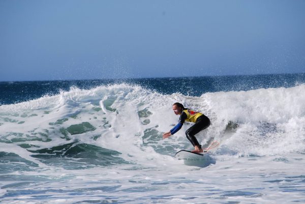Niña cogiendo olas con la Escuela de Surf Kotadalu en Cádiz