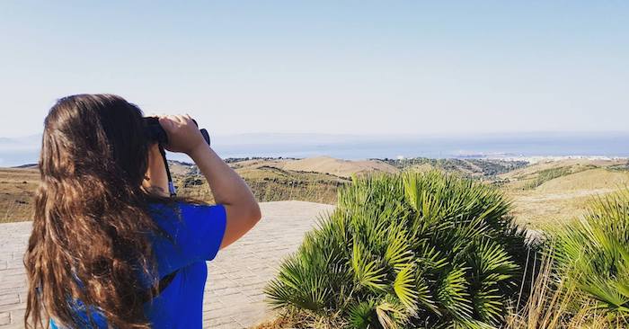 Chica observando aves en el centro internacional de Migración de Aves en Tarifa