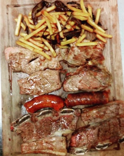 Tabla de carne con patatas en el meson Brasería Eguren en Vinuesa en la provincia de Soria