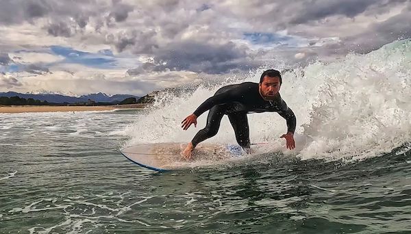 Alumno de la escuela de Meron Surf practicando surf en San Vicente de la Barquera en Cantabria