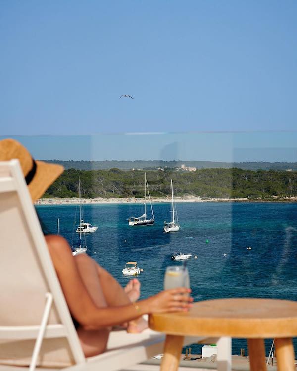 Turista tomando un refresco en la terraza del Hotel Honucai en Mallorca